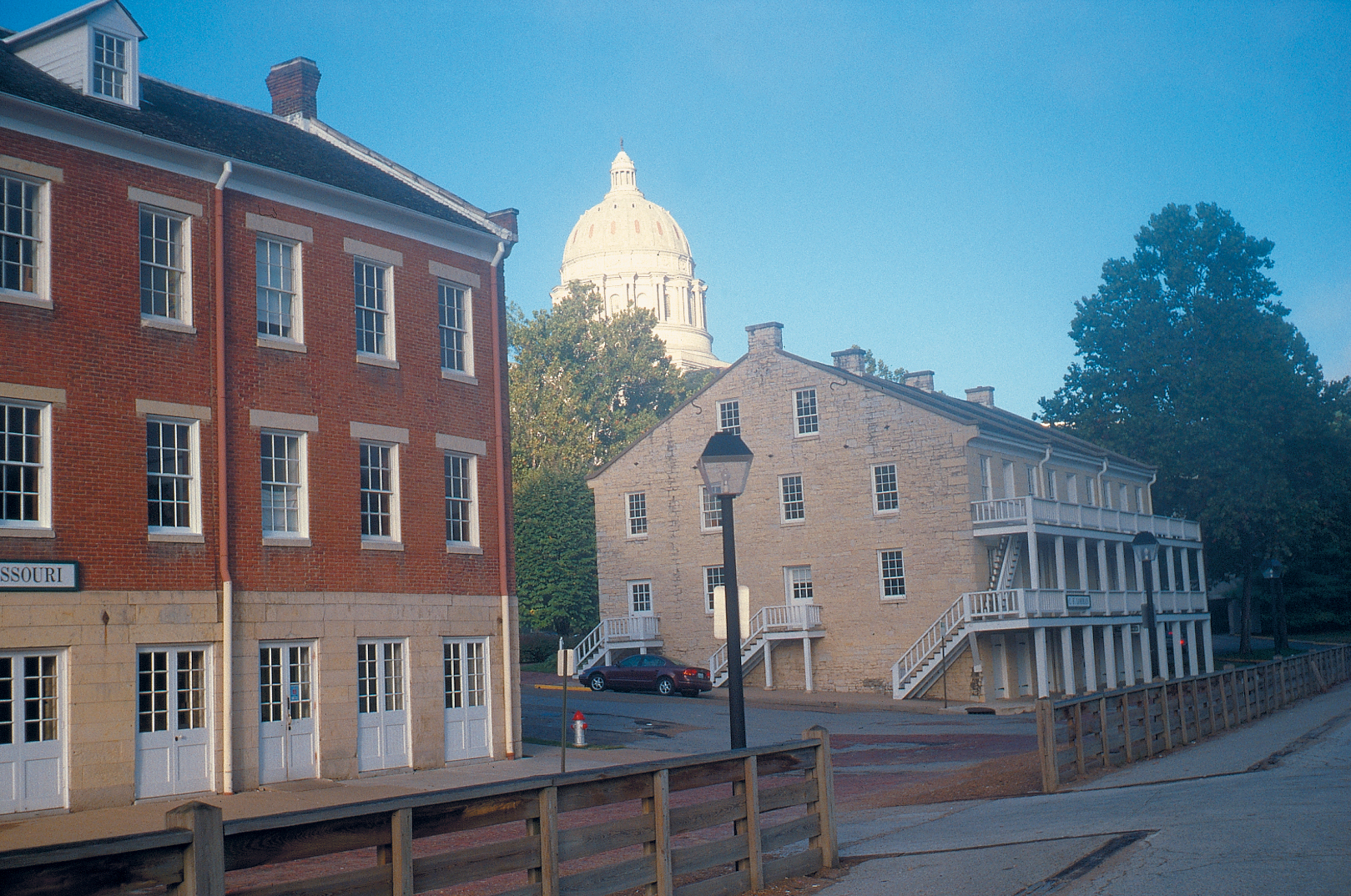 the red brick Union Hotel and the white rock Lohman Building with the dome of the State Capitol in the background between them