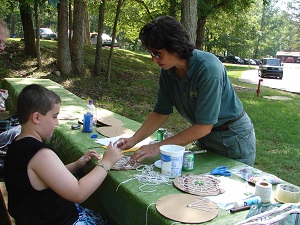 staff helping a child with a craft project