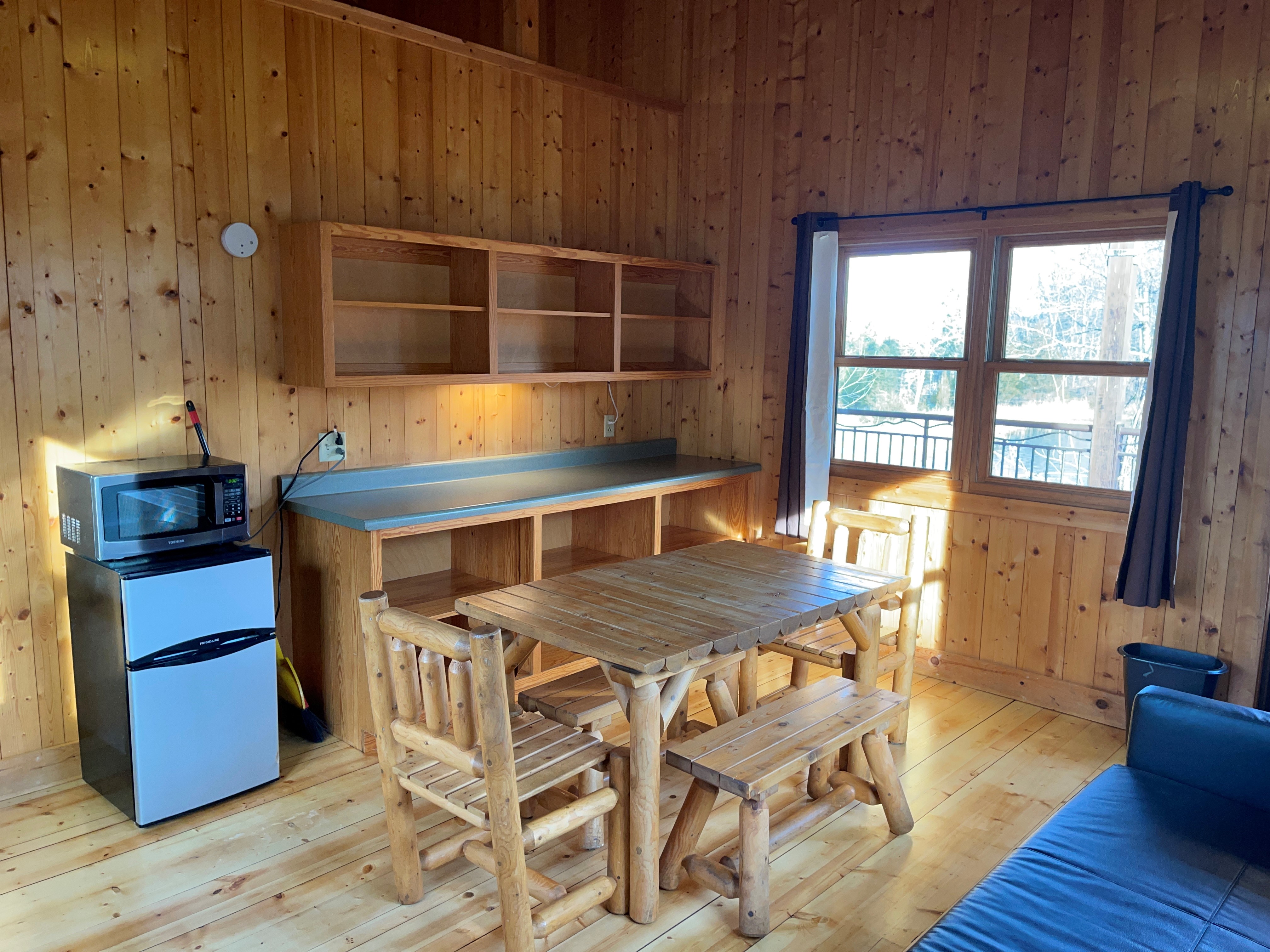 Table, mini fridge, microwave and cupboard inside cabin