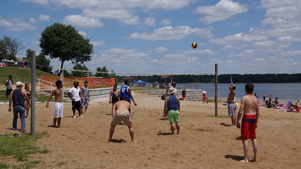 a group playing volleyball on the beach