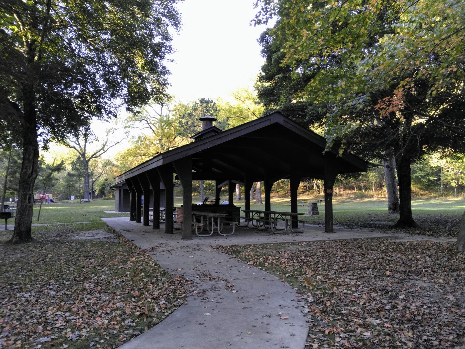 Open picnic shelter with playground in the background