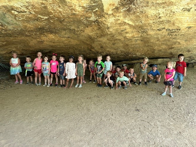 Students pose for a photo in the mouth of a cave