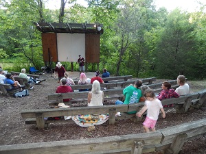 people sitting on the wood amphitheater benches listening to a program