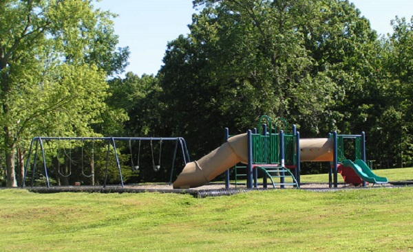 playground equipment with two small slides and a swing set