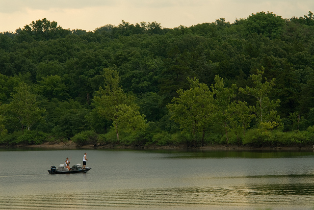 people in a boat fishing on the lake