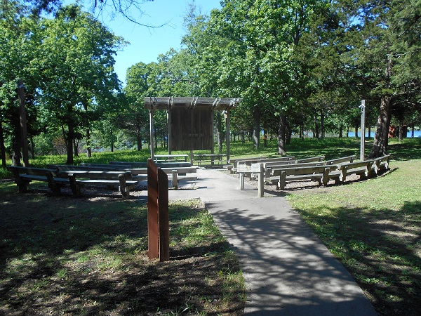 sidewalk leads to wooden benches and stage of amphitheater