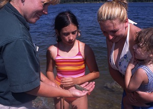 a naturalist shows a family small fish