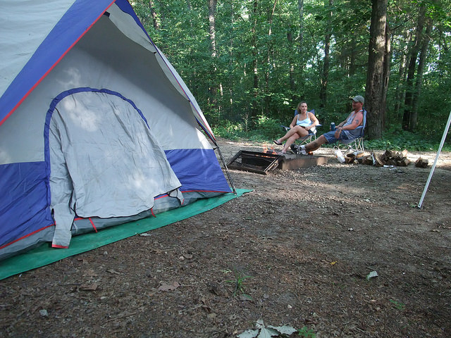 a couple sitting by their tent