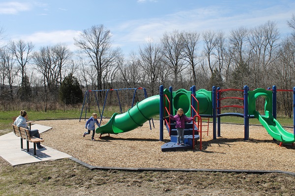 kids playing on the playground equipment that features slides