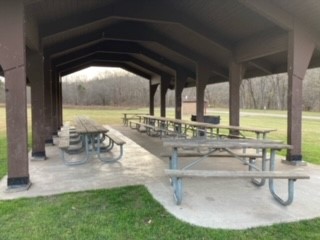 Picnic tables under the roof of the open shelter