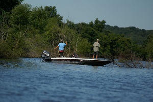 two people fishing from a boat on the lake