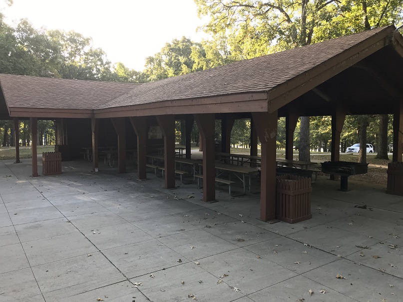 Open picnic shelter, with trash cans and a grill