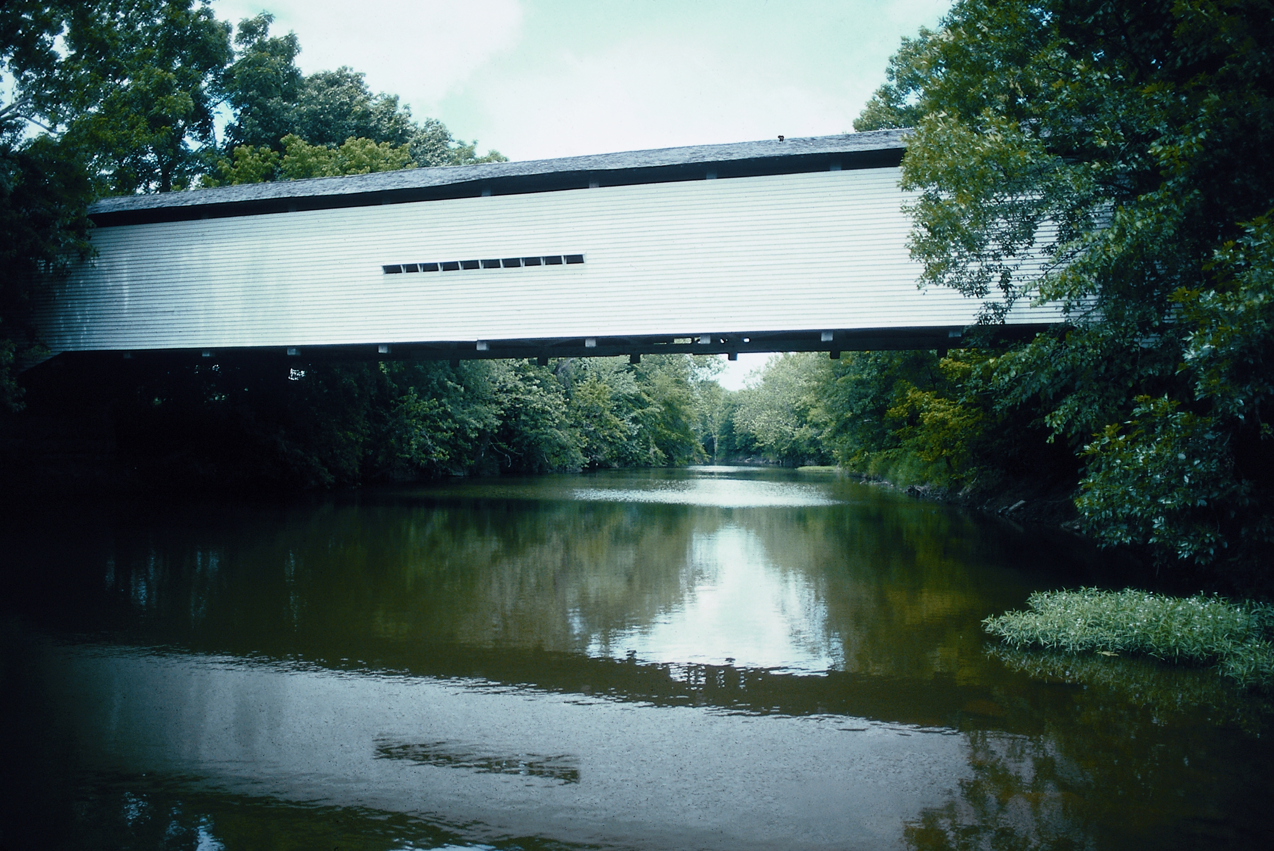 the covered bridge spanning over the creek
