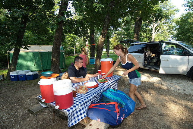 a family at the picnic table in front of their tent