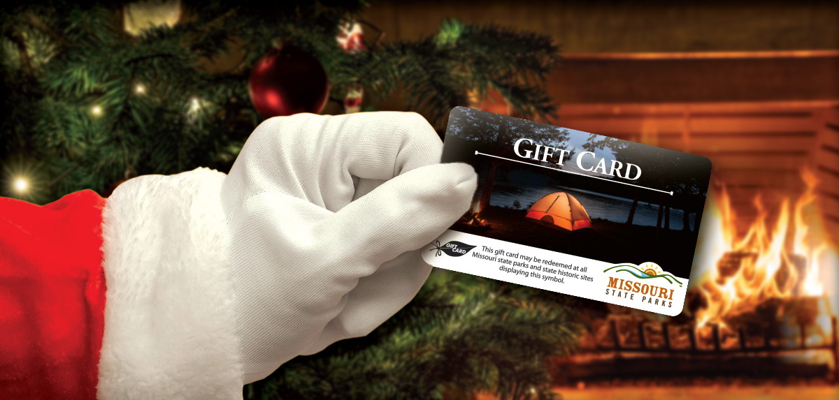 White gloved hand holding a Missouri State Parks gift card.